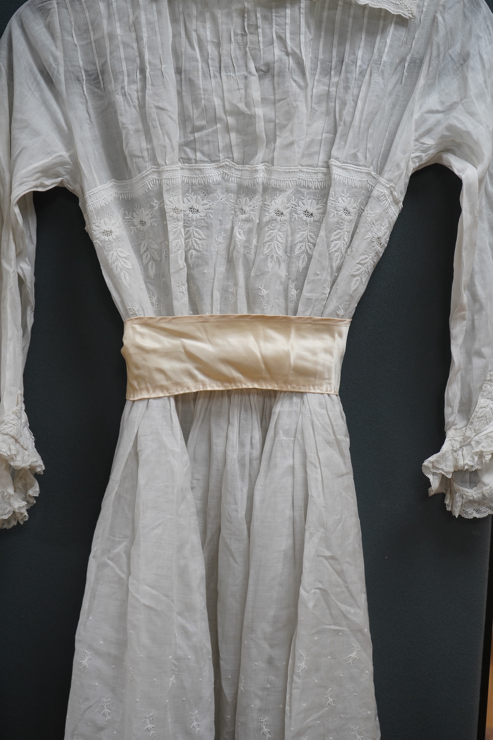 Two late 19th early 20th century girls summer dresses, one fine cotton with white worked collar cuffs and bodice, the other a cotton twill with anglaise collar large puff sleeves and gathered across the chest, lawn dress